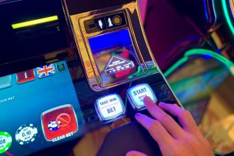 Mão interagindo com botões de uma interface colorida de máquina caça-níqueis.